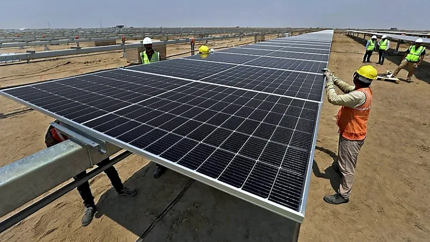 Crew lifting a PV module onto a fixed-tilt mounting structure